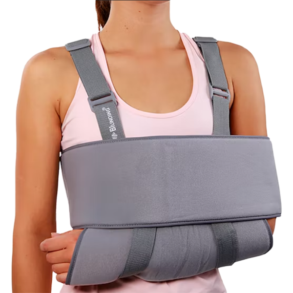 Persona utilizando el inmovilizador de hombro Blunding de color azul marino, con bandas cruzadas y soporte de brazo. Producto de Medicalab SPA